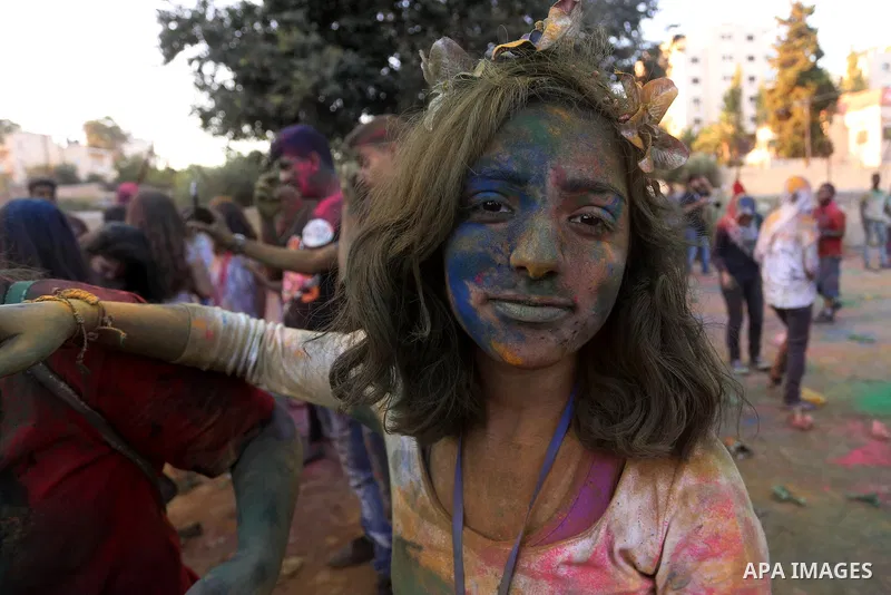 A Palestinian girl poses for a photograph during the festival of colour battle in the West Bank city of Ramallah on August 20, 2015. Photo by Shadi Hatem