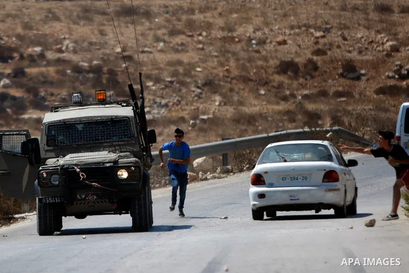 Palestinian protesters throw stones at Israeli security forces during clashes following a protest against Jewish settlements in the West Bank village of Nabi Saleh, near Ramallah August 21, 2015. Photo by Shadi Hatem