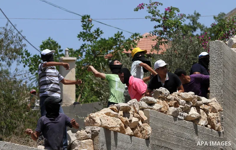 Palestinian protesters throw stones towards Israeli security forces during clashes following a demonstration against the expropriation of Palestinian land by Israel in the village of Kfar Qaddum, near Nablus in the occup...