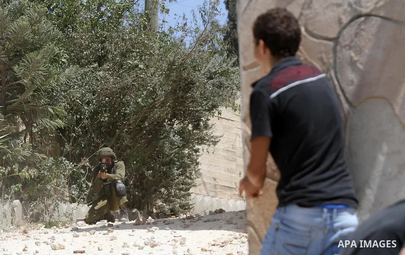 A Palestinian protester throws stones towards Israeli security forces during clashes following a demonstration against the expropriation of Palestinian land by Israel in the village of Kfar Qaddum, near Nablus in the occ...