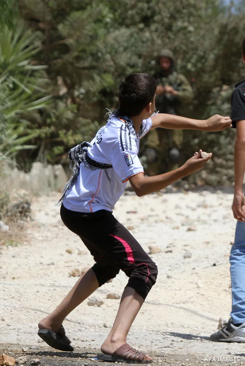 A Palestinian protester throws stones towards Israeli security forces during clashes following a demonstration against the expropriation of Palestinian land by Israel in the village of Kfar Qaddum, near Nablus in the occ...