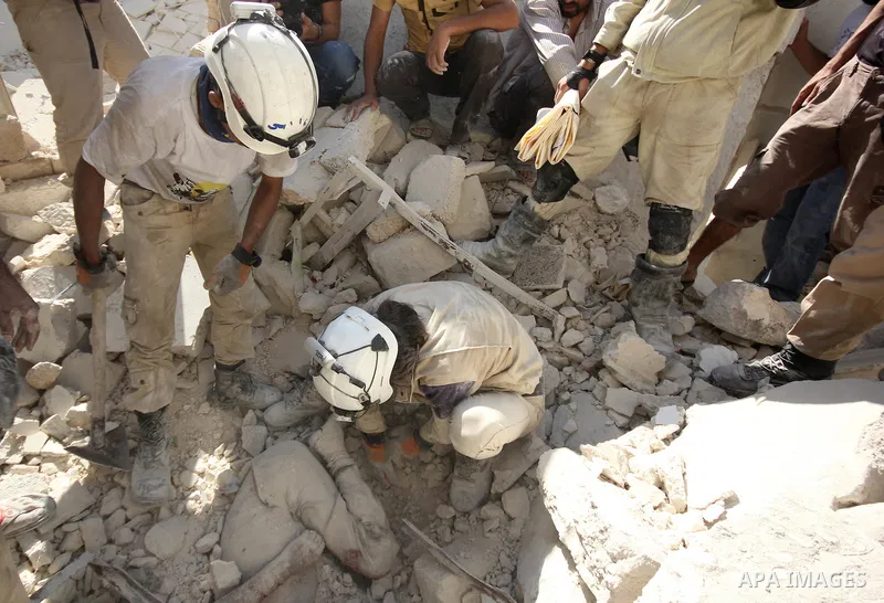 Syrian rescue workers remove a body from under the rubble following a reported barrel-bomb attack by Syrian government forces, in the Tariq al-Bab neighbourhood in the northern city of Aleppo, on August 21, 2015. Photo b...