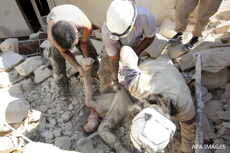 Syrian rescue workers remove a body from under the rubble following a reported barrel-bomb attack by Syrian government forces, in the Tariq al-Bab neighbourhood in the northern city of Aleppo, on August 21, 2015. Photo b...