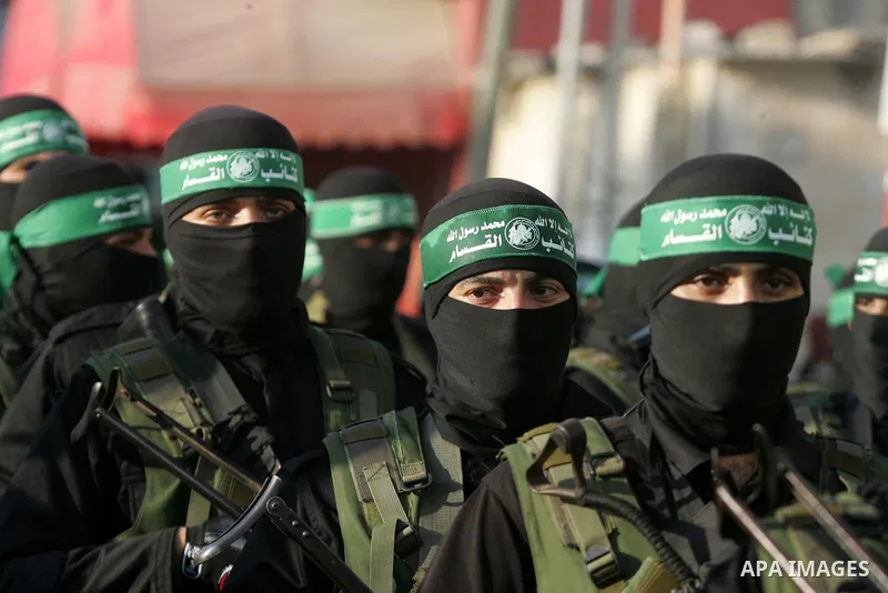 Palestinian members of the al-Qassam Brigades, the armed wing of the Hamas movement, take part in a military parade marking the first anniversary of the killing of Hamas's military commanders Mohammed Abu Shamala and Rae...