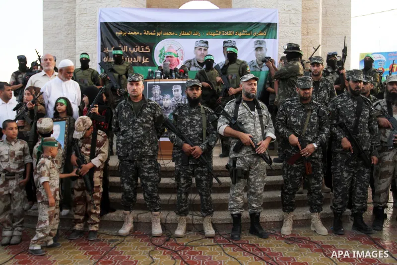 Palestinian members of the al-Qassam Brigades, the armed wing of the Hamas movement, take part in a military parade marking the first anniversary of the killing of Hamas's military commanders Mohammed Abu Shamala and Rae...
