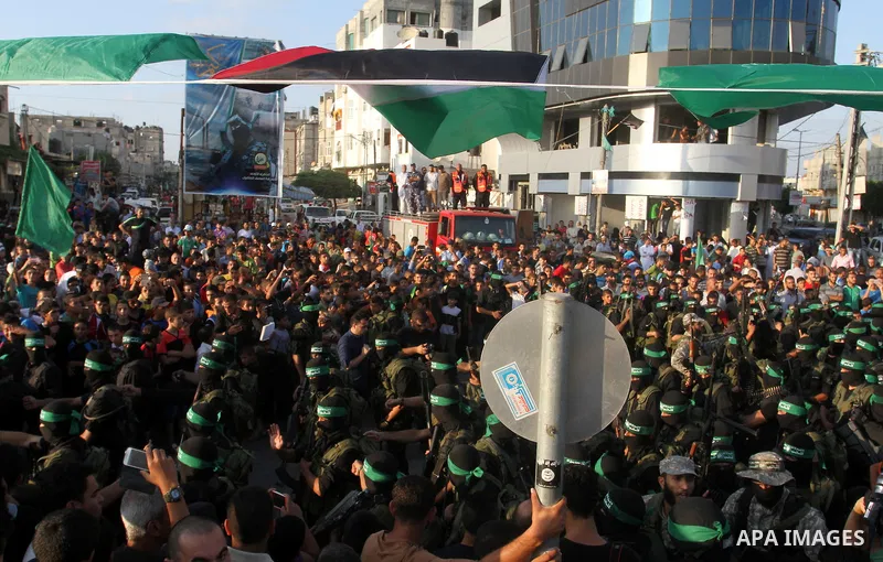 Palestinian members of the al-Qassam Brigades, the armed wing of the Hamas movement, take part in a military parade marking the first anniversary of the killing of Hamas's military commanders Mohammed Abu Shamala and Rae...