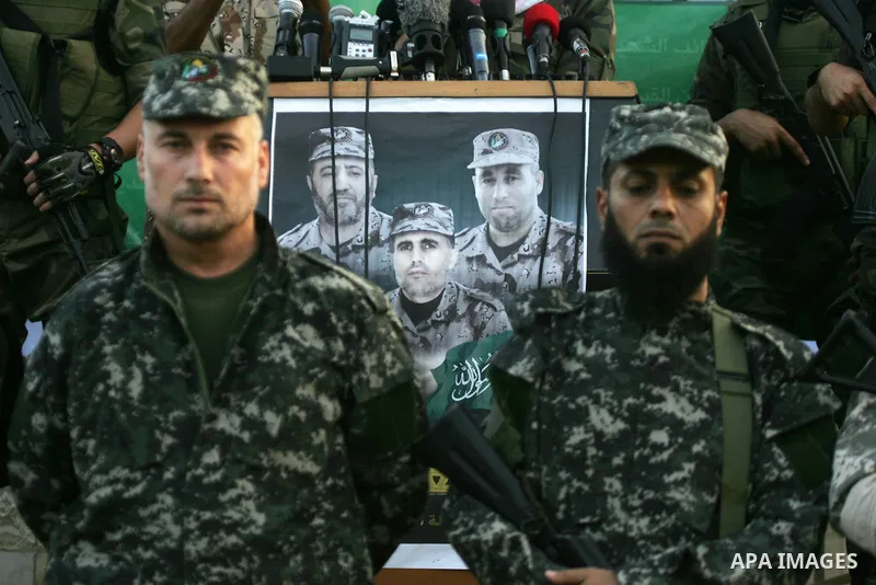 Palestinian members of the al-Qassam Brigades, the armed wing of the Hamas movement, take part in a military parade marking the first anniversary of the killing of Hamas's military commanders Mohammed Abu Shamala and Rae...