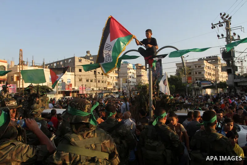 Palestinian members of the al-Qassam Brigades, the armed wing of the Hamas movement, take part in a military parade marking the first anniversary of the killing of Hamas's military commanders Mohammed Abu Shamala and Rae...