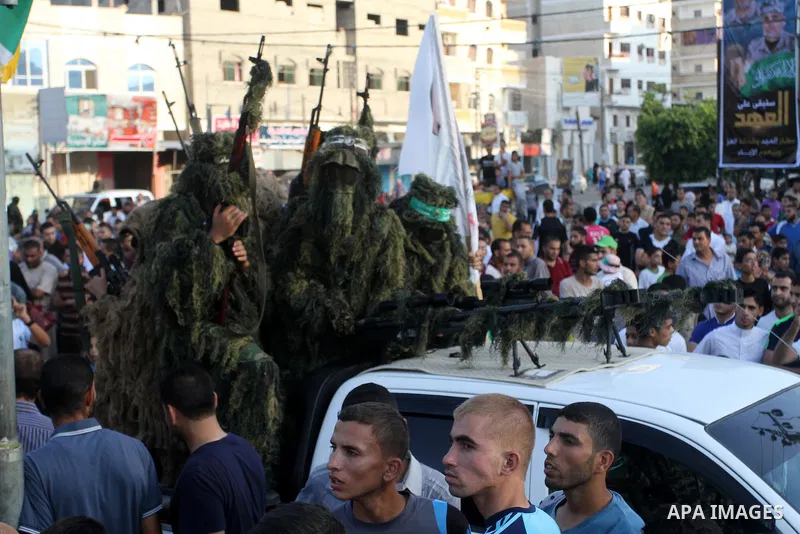 Palestinian members of the al-Qassam Brigades, the armed wing of the Hamas movement, take part in a military parade marking the first anniversary of the killing of Hamas's military commanders Mohammed Abu Shamala and Rae...