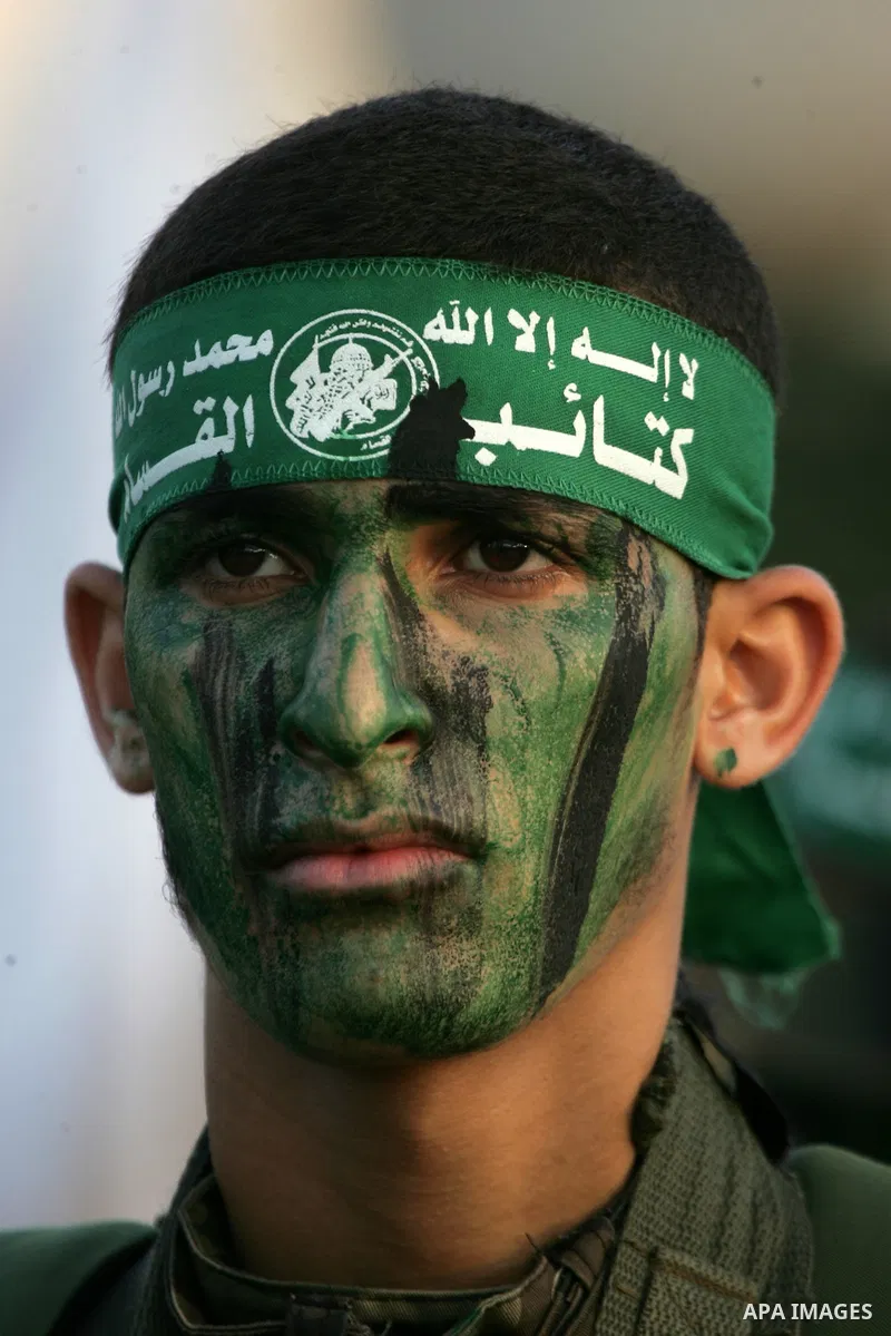 A Palestinian member of the al-Qassam Brigades, the armed wing of the Hamas movement, takes part in a military parade marking the first anniversary of the killing of Hamas's military commanders Mohammed Abu Shamala and R...