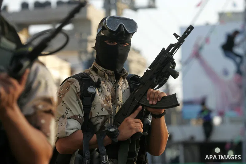 Palestinian members of the al-Qassam Brigades, the armed wing of the Hamas movement, take part in a military parade marking the first anniversary of the killing of Hamas's military commanders Mohammed Abu Shamala and Rae...