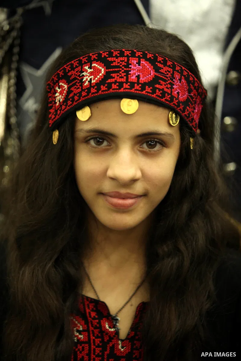A Palestinian girl looks on as she watch members of musical band from "Edward Said National Conservatory of Music" perform in a festival of "Sea and Freedom" in Gaza city on August 22, 2015. Photo by Ashraf Amra