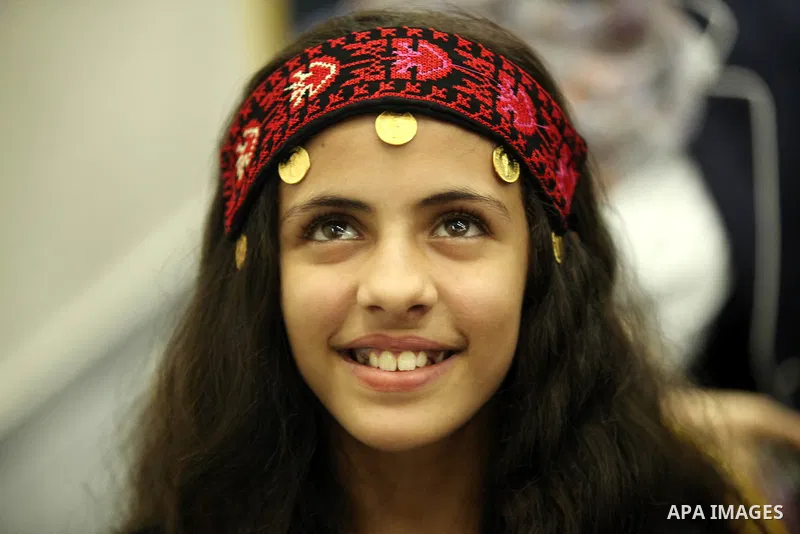 A Palestinian girl looks on as she watch members of musical band from "Edward Said National Conservatory of Music" perform in a festival of "Sea and Freedom" in Gaza city on August 22, 2015. Photo by Ashraf Amra