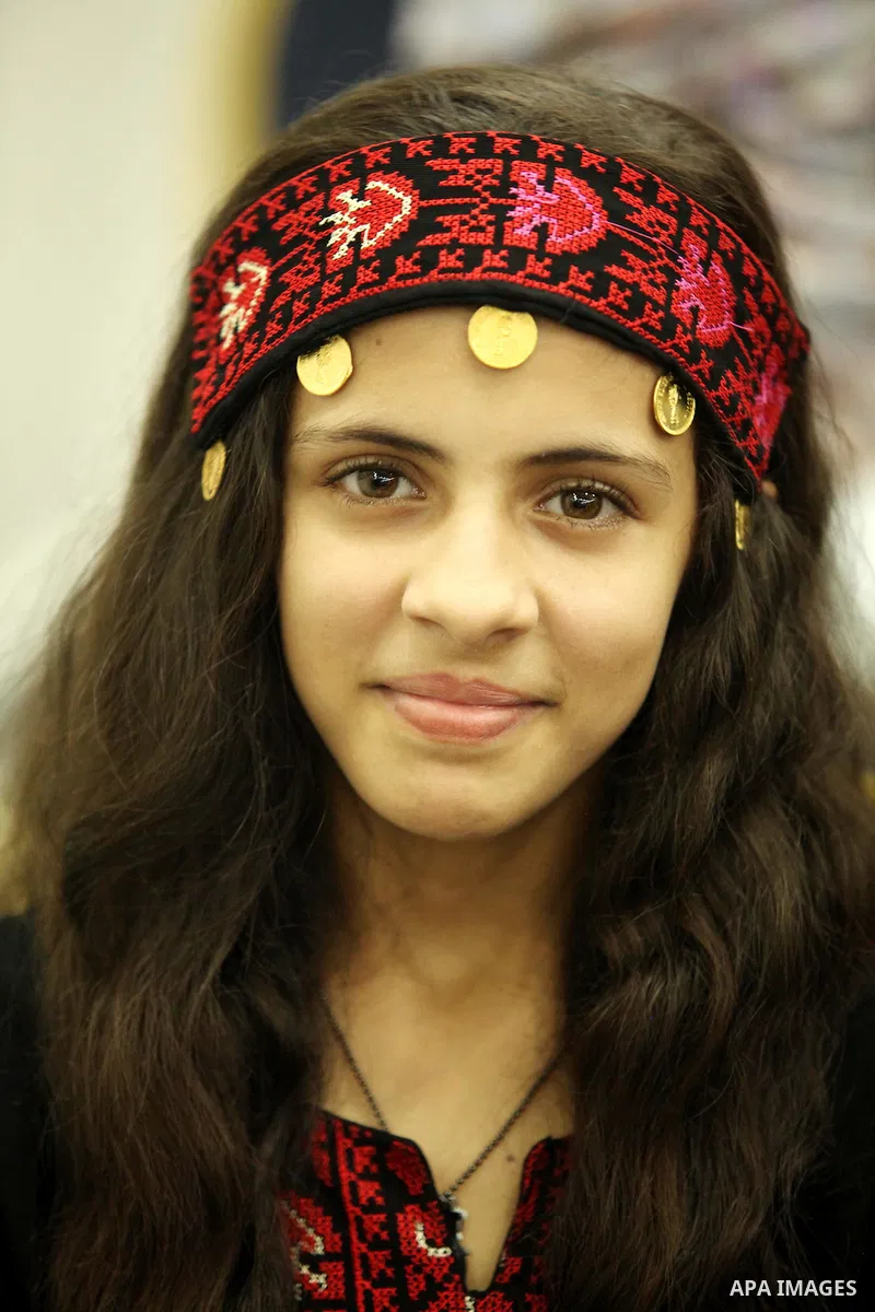 A Palestinian girl looks on as she watch members of musical band from "Edward Said National Conservatory of Music" perform in a festival of "Sea and Freedom" in Gaza city on August 22, 2015. Photo by Ashraf Amra