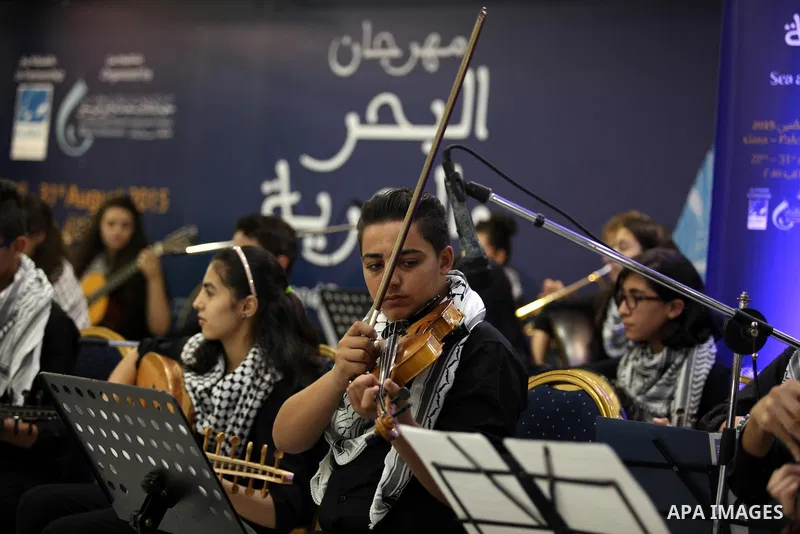 Palestinian members of musical band from "Edward Said National Conservatory of Music" perform in a festival of "Sea and Freedom" in Gaza city on August 22, 2015. Photo by Ashraf Amra