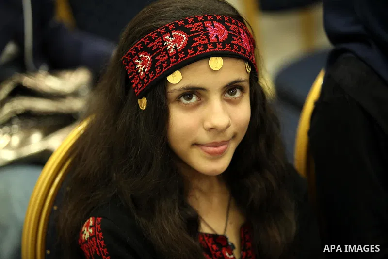 A Palestinian girl looks on as she watch members of musical band from "Edward Said National Conservatory of Music" perform in a festival of "Sea and Freedom" in Gaza city on August 22, 2015. Photo by Ashraf Amra