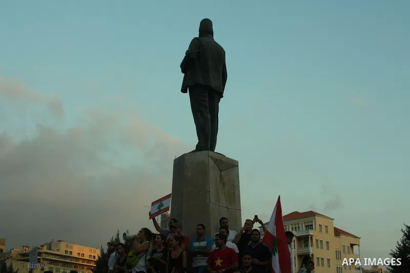 Lebanese protesters hold banners and national flags during a demonstration, against the ongoing trash crisis in the capital Beirut on August 22, 2015. Thousands of protesters, including children, gathered to protest the...