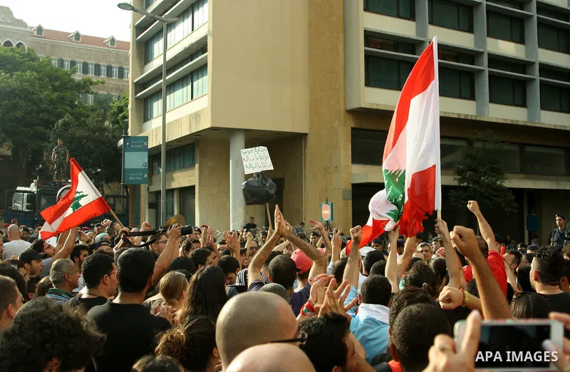 Lebanese protesters hold banners and national flags during a demonstration, against the ongoing trash crisis in the capital Beirut on August 22, 2015. Thousands of protesters, including children, gathered to protest the...