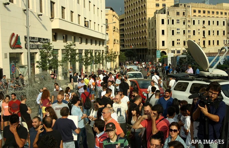 Lebanese protesters hold banners and national flags during a demonstration, against the ongoing trash crisis in the capital Beirut on August 22, 2015. Thousands of protesters, including children, gathered to protest the...