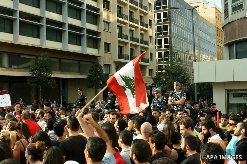 Lebanese protesters hold banners and national flags during a demonstration, against the ongoing trash crisis in the capital Beirut on August 22, 2015. Thousands of protesters, including children, gathered to protest the...