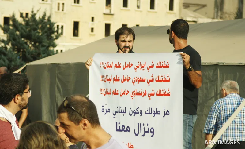 Lebanese protesters hold banners and national flags during a demonstration, against the ongoing trash crisis in the capital Beirut on August 22, 2015. Thousands of protesters, including children, gathered to protest the...