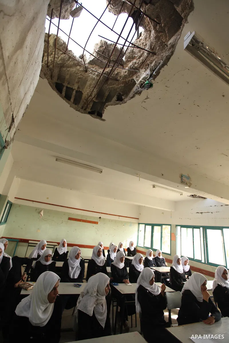 Palestinian schoolgirls attend a lesson inside a classroom, on the first day of a new school year at Suhada Khouza school in Khan Younis in the southern Gaza Strip August 24, 2015. Photo by Ashraf Amra
