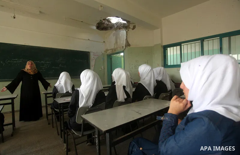 Palestinian schoolgirls attend a lesson inside a classroom, on the first day of a new school year at Suhada Khouza school in Khan Younis in the southern Gaza Strip August 24, 2015. Photo by Ashraf Amra