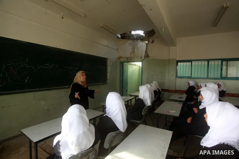 Palestinian schoolgirls attend a lesson inside a classroom, on the first day of a new school year at Suhada Khouza school in Khan Younis in the southern Gaza Strip August 24, 2015. Photo by Ashraf Amra
