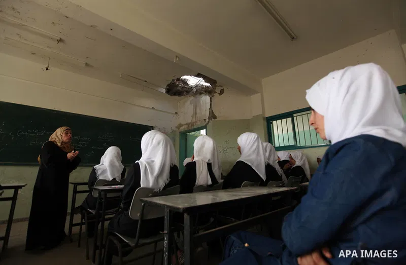 Palestinian schoolgirls attend a lesson inside a classroom, on the first day of a new school year at Suhada Khouza school in Khan Younis in the southern Gaza Strip August 24, 2015. Photo by Ashraf Amra