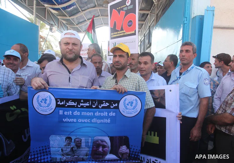 Palestinian employees of the United Nations hold placards during a protest against the reduction of educational programs given by the United Nations Relief and Works Agency (UNRWA) on August 24, 2015 outside the UNESCO h...