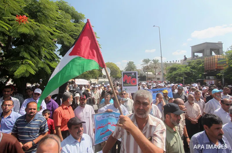 Palestinian employees of the United Nations hold placards during a protest against the reduction of educational programs given by the United Nations Relief and Works Agency (UNRWA) on August 24, 2015 outside the UNESCO h...