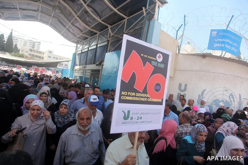 Palestinian employees of the United Nations hold placards during a protest against the reduction of educational programs given by the United Nations Relief and Works Agency (UNRWA) on August 24, 2015 outside the UNESCO h...