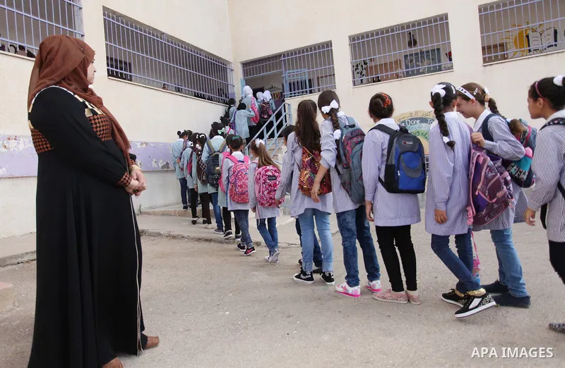 Palestinian students stand in a line at their school in the morning of the first day of the new year study in the West Bank village of Duma, near Nablus on August 24, 2015. Photo by Shadi Jarar'ah