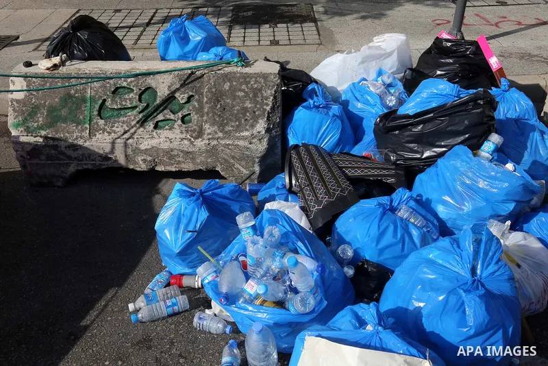 A view taken on August 23, 2015, shows large amounts of garbage surrounding a car in Baabda east of the Lebanese capital, Beirut. The humid summer air of Beirut has started to reek as uncollected trash piles up in the st...