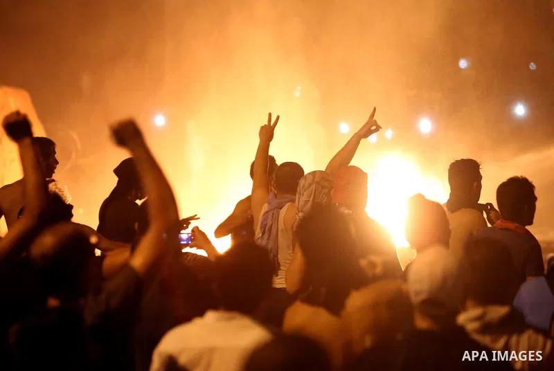 Lebanese protesters shout slogans next to a burning police motorcycle during clashes with riot police following a demonstration, organized by "You Stink" campaign, to protest against the ongoing country's trash crisis in...