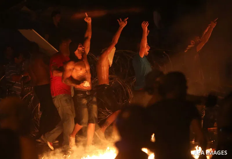 Lebanese protesters shout slogans next to a burning police motorcycle during clashes with riot police following a demonstration, organized by "You Stink" campaign, to protest against the ongoing country's trash crisis in...
