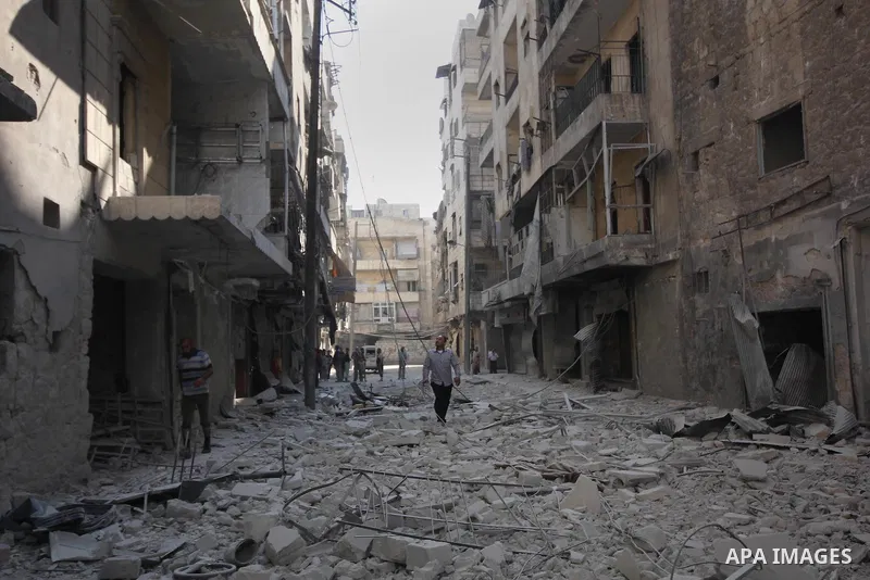 Syrian men walk on the rubble of buildings following a reported bomb barrel attack by Syrian government forces at Salah AL-Dien neighborhood in the northern Syrian city of Aleppo, August 25, 2015. Photo by Ameer al-Halbi