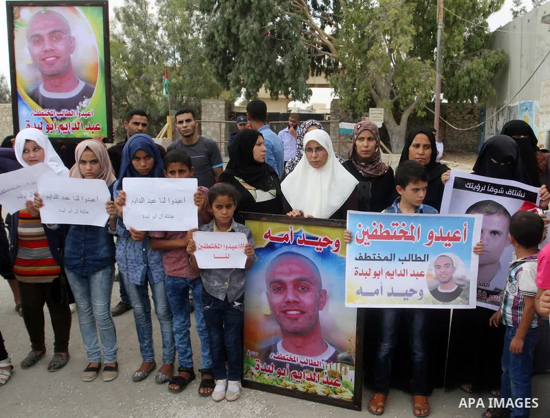 Families of Palestinians who were abducted of by gunmen is Egypt's Sinai's northern region, take part in a demonstration calling for the release at the Rafah border crossing with Egypt in the southern Gaza Strip, on Augu...