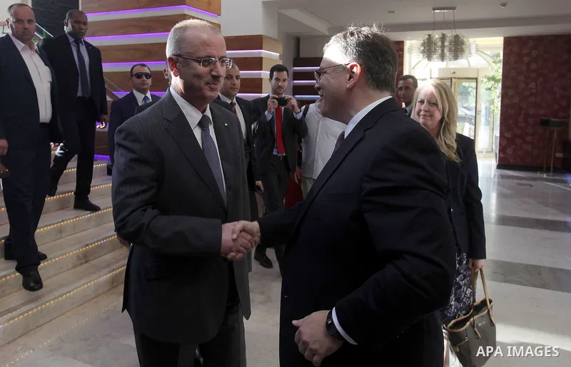Palestinian Prime Minister Rami Hamdallah shakes hands with US Consul General in Jerusalem Donald Bloom during a ceremony of receiving his duties in Palestinian Territories, in the West Bank city of Ramallah on August 27...