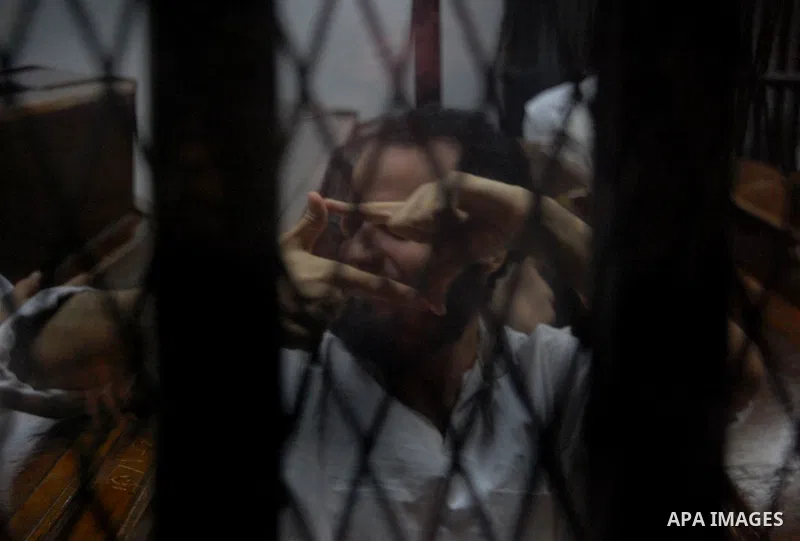 Egyptian suspects in the case of Suez terrorist group sit behind bars during during their trial, at a court, in Cairo, Egypt on August 29, 2015. Photo by Amr Sayed