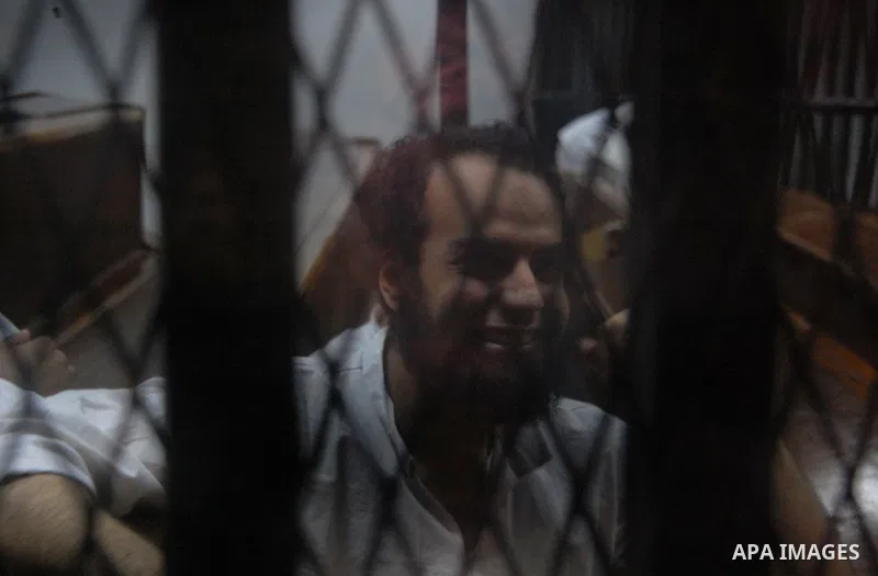 Egyptian suspects in the case of Suez terrorist group sit behind bars during during their trial, at a court, in Cairo, Egypt on August 29, 2015. Photo by Amr Sayed