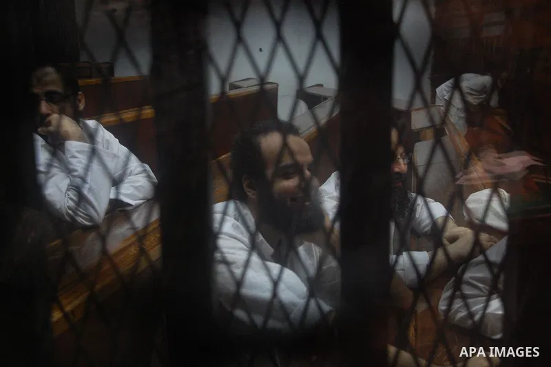 Egyptian suspects in the case of Suez terrorist group sit behind bars during during their trial, at a court, in Cairo, Egypt on August 29, 2015. Photo by Amr Sayed