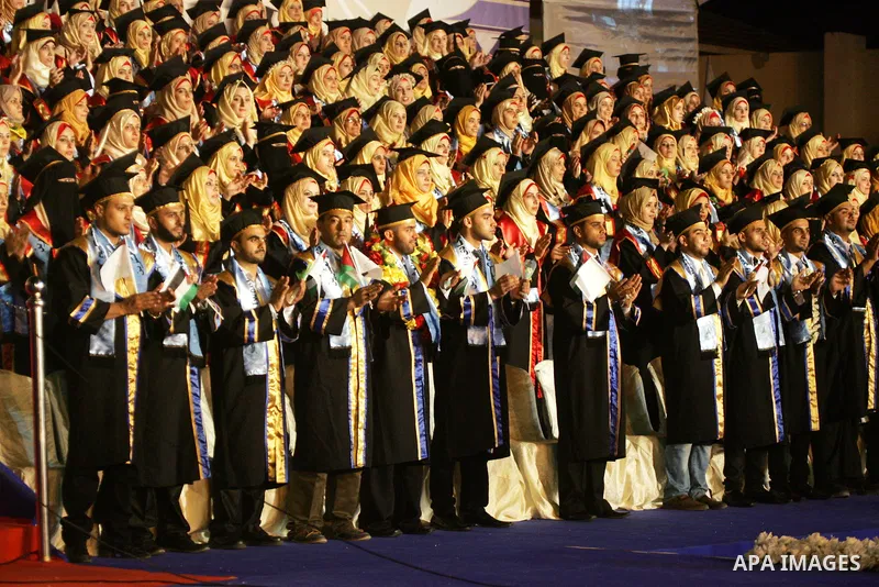 Palestinian students take part in their graduation ceremony at Al-Aqsa University in Khan Younis in the southern of Gaza strip on August 29, 2015. Photo by Abed Rahim Khatib