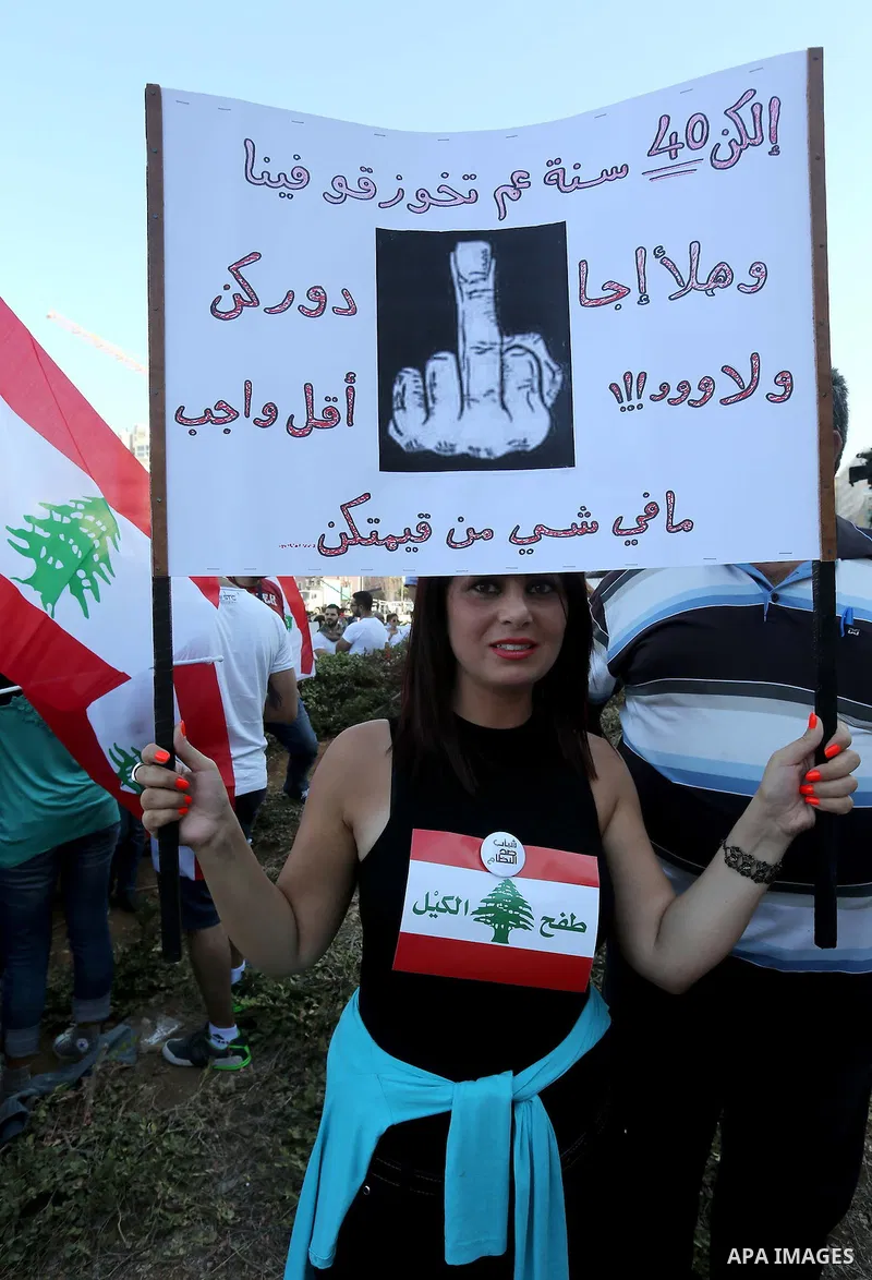 People carry Lebanese national flags and chant slogans as they take part in an anti-government protest at Martyrs' Square in downtown Beirut, Lebanon August 29, 2015. Thousands of protesters waving Lebanese flags and cha...