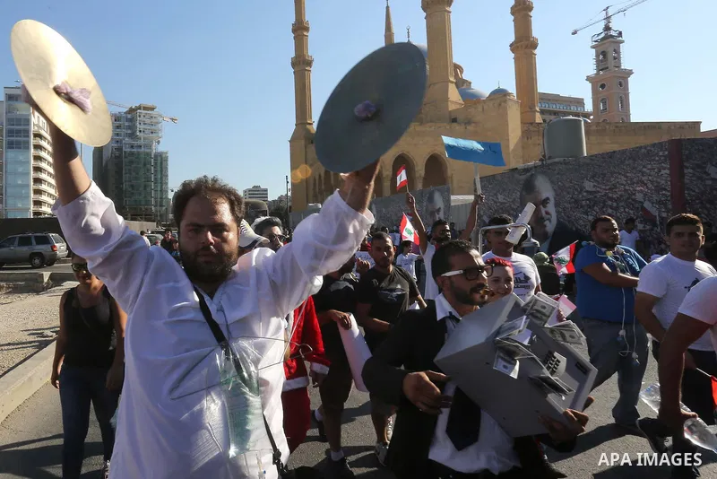 People carry Lebanese national flags and chant slogans as they take part in an anti-government protest at Martyrs' Square in downtown Beirut, Lebanon August 29, 2015. Thousands of protesters waving Lebanese flags and cha...