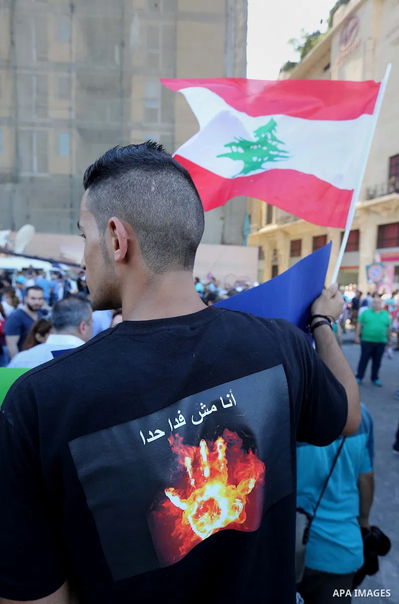 People carry Lebanese national flags and chant slogans as they take part in an anti-government protest at Martyrs' Square in downtown Beirut, Lebanon August 29, 2015. Thousands of protesters waving Lebanese flags and cha...