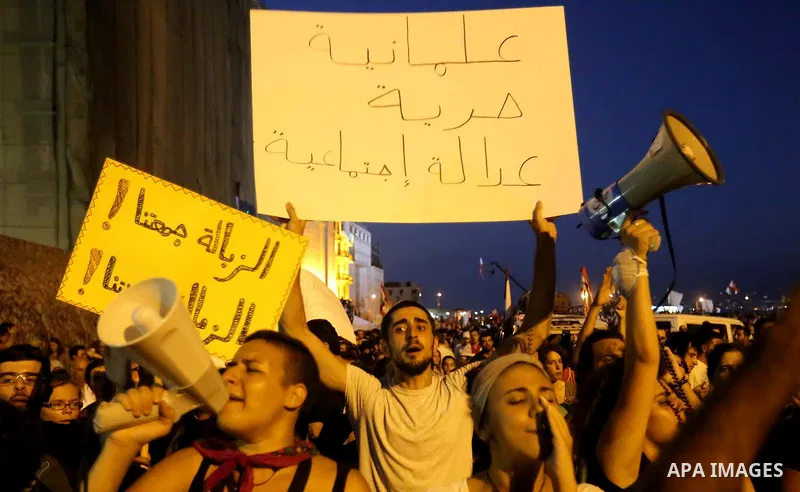 People carry Lebanese national flags and chant slogans as they take part in an anti-government protest at Martyrs' Square in downtown Beirut, Lebanon August 29, 2015. Thousands of protesters waving Lebanese flags and cha...