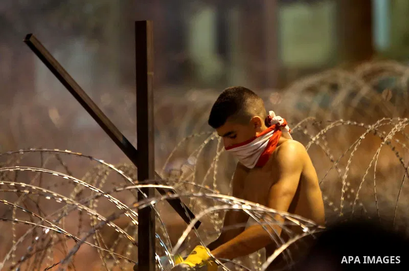 Protesters carry banners and Lebanese national flags as they stand near barbed wire erected near the government palace in downtown Beirut, Lebanon August 29, 2015. Thousands of protesters waving Lebanese flags and chanti...