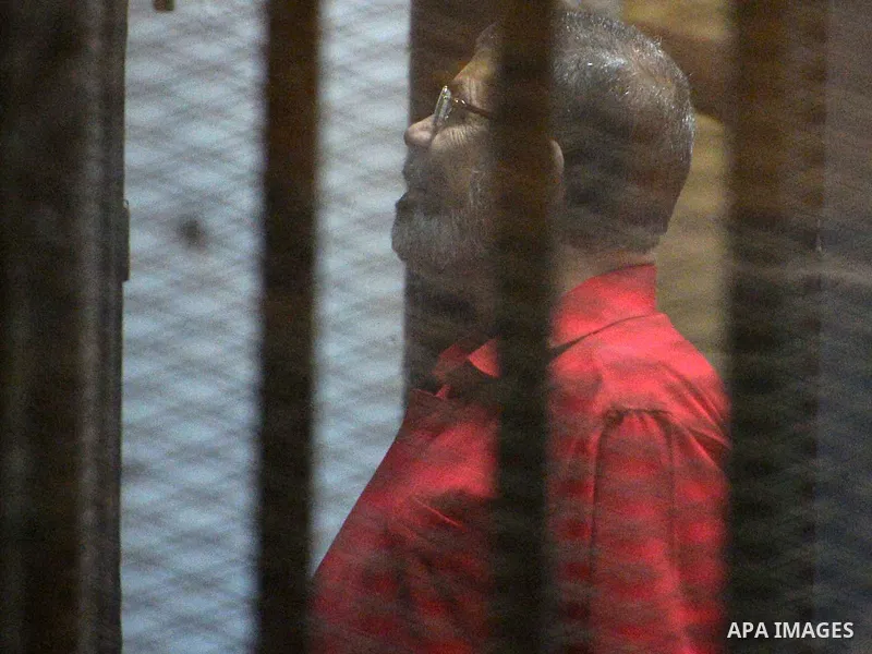 Ousted Egyptian president Mohammed Morsi speaks to the judge as he stands behind bars during his trail in a court in Cairo on August 30, 2015. Cairo criminal court resumes today the trial of deposed president Mohamed Mor...