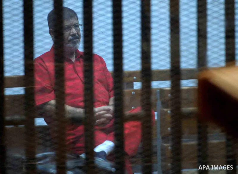 Ousted Egyptian president Mohammed Morsi sits behind bars during his trail in a court in Cairo on August 30, 2015. Cairo criminal court resumes today the trial of deposed president Mohamed Morsi and 10 others on charges...